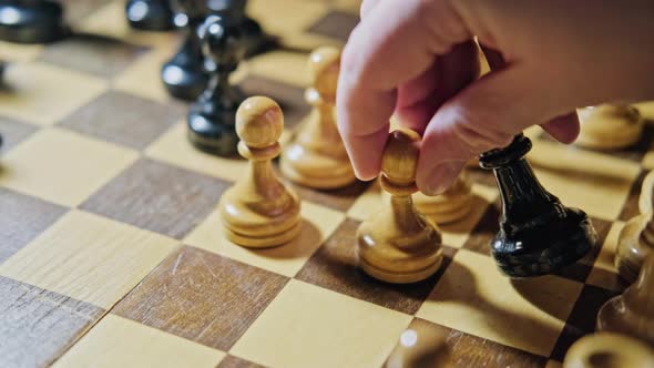 The capture of the bishop by the white pawn in a chess game. Man hand with a chess piece 