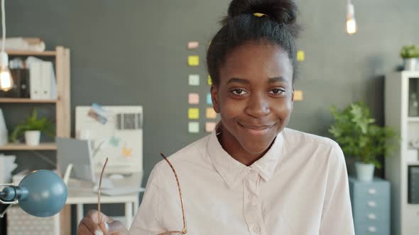 Portrait of Attractive Afro-American Woman Looking at Camera with Serious Face Then Smiling in alt