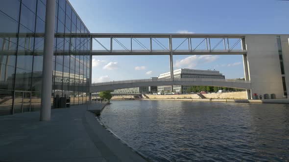 A river quay by a building with a glass facade