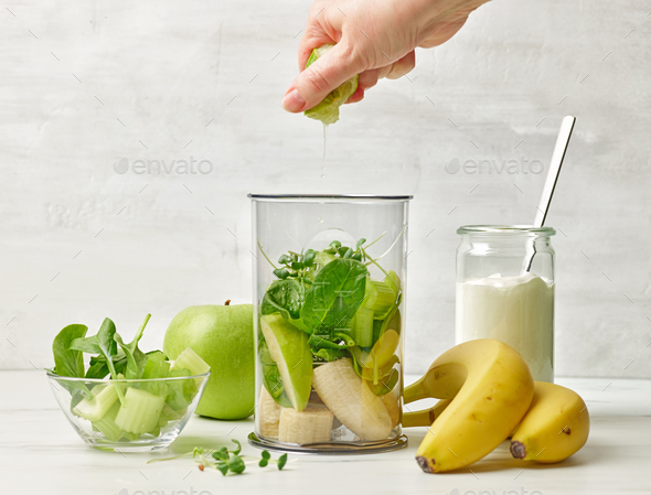 banana and various green vegetables in blender container - Stock Photo - Images