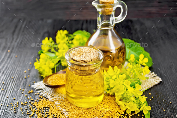 Oil mustard in jar and decanter with flower on board Stock Photo by rezkrr