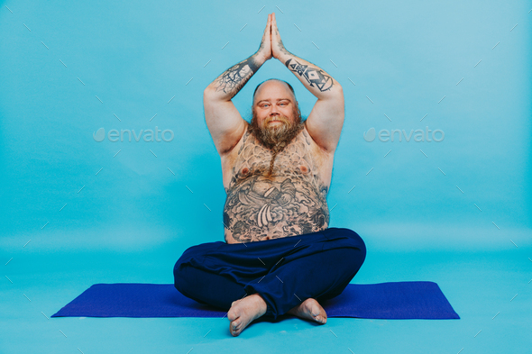 Funny fat man doing yoga meditation Stock Photo by oneinchpunchphotos