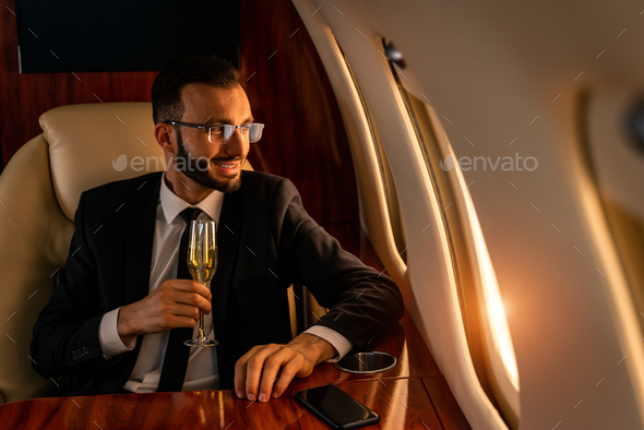 Businessman flying on private jet - Stock Photo - Images
