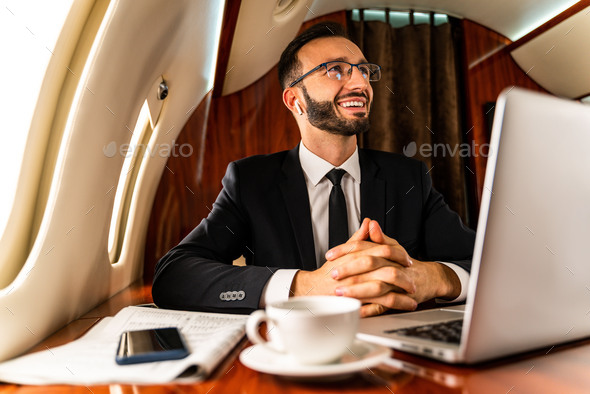 Businessman flying on private jet - Stock Photo - Images