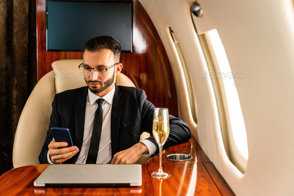 Businessman flying on private jet - Stock Photo - Images