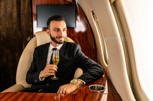 Businessman flying on private jet - Stock Photo - Images