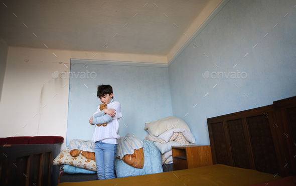 Poor sad small girl in bedroom indoors at home, poverty concept Stock ...