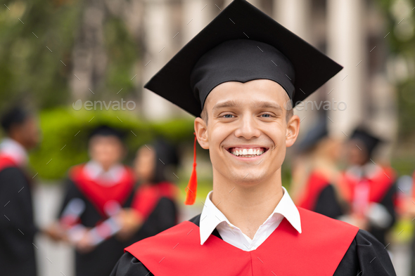 Handsome guy student posing in graduation costume