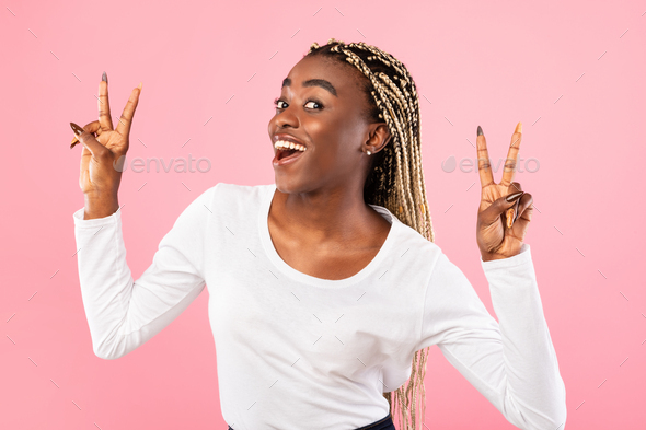 Happy black woman showing two victory sign or peace gesture