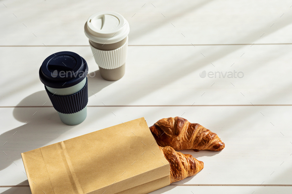 Hot coffee on the go and croissants for breakfast. Biodegradable, reusable takeaway cup