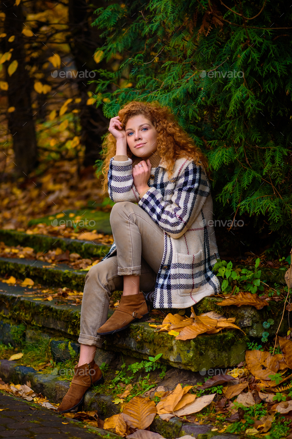 Beautiful red-haired girl with curly hair and blue eyes. Stock Photo by  wolfhound9111