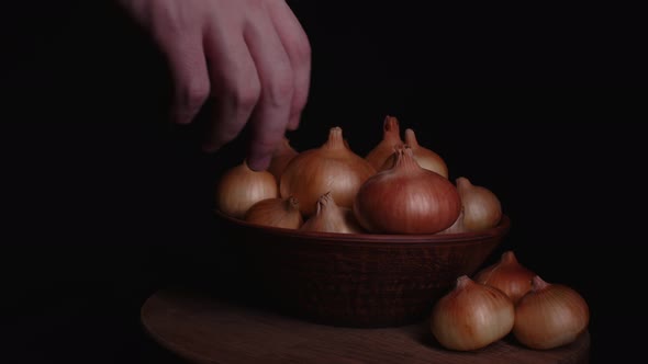 Pile of Whole Bulbs of Raw Onion in Ceramic Bowl on Table alt