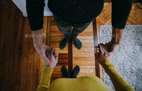 Couple dancing in the living room, pov view from above right on the feet and the wood floor