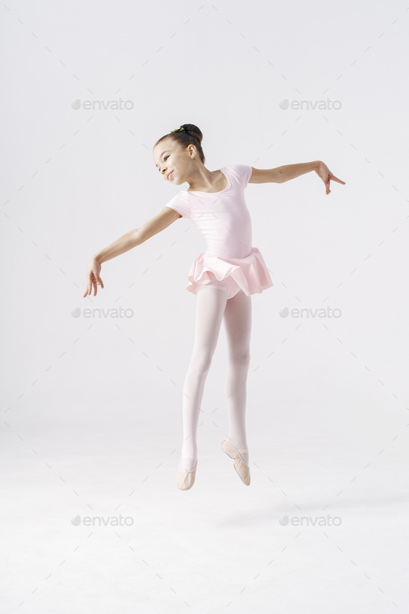 Adorable pre-teen ballerina jumping on background Stock by diignat