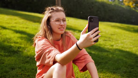 Video Communication Via Smartphone with a Summer City Park alt