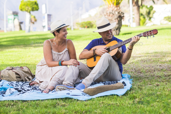 Romantic happy nice caucasian couple people playing a guitar for romantic activity