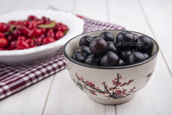 side view cherry plum in a bowl with dogwood on a plate