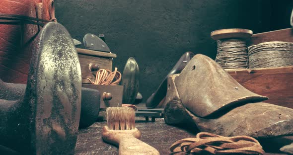 Shoemaker workshop with tools, anvil, shoes and rule. alt