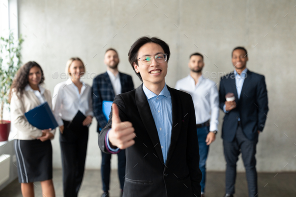 Asian Businessman Gesturing Thumbs-Up Standing With Employees Team In Office