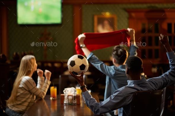 Football fans watching game translation in bar