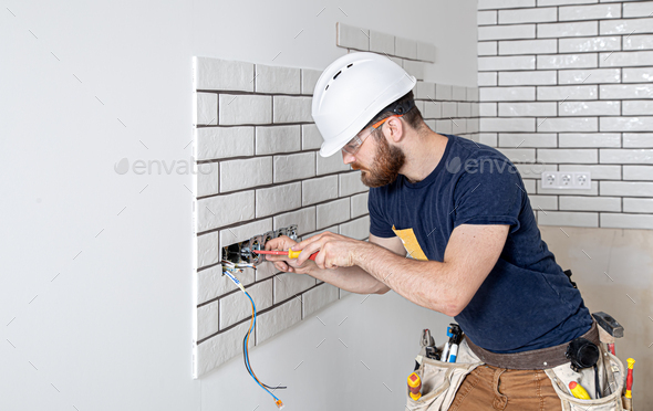 Electrician Builder at work, installation of sockets and switches.
