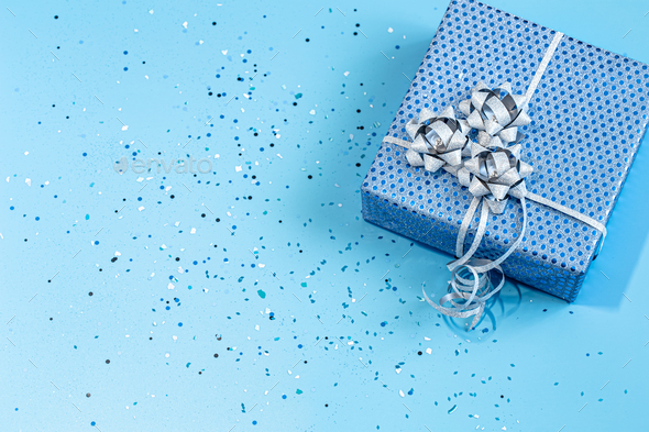 Gift box Packed in blue paper on a blue background . Stock Photo by puhimec