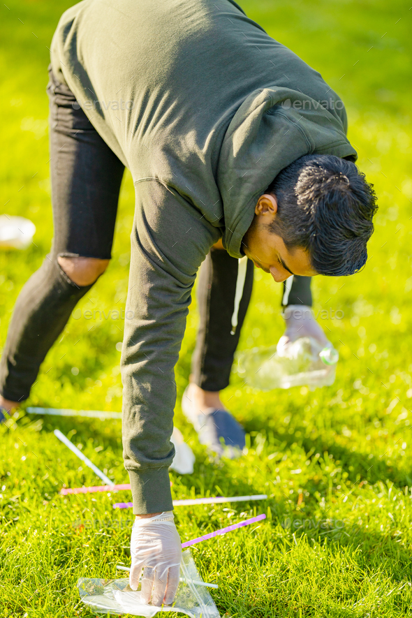 Volunteer cleaning park for garbage and plastic on sunny day - Stock Photo - Images