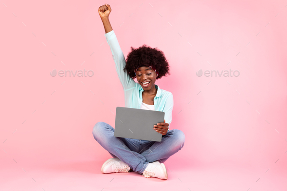 Joyful Black Lady With Laptop Shaking Fists On Pink Background
