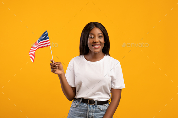 Positive black woman student holding american flag