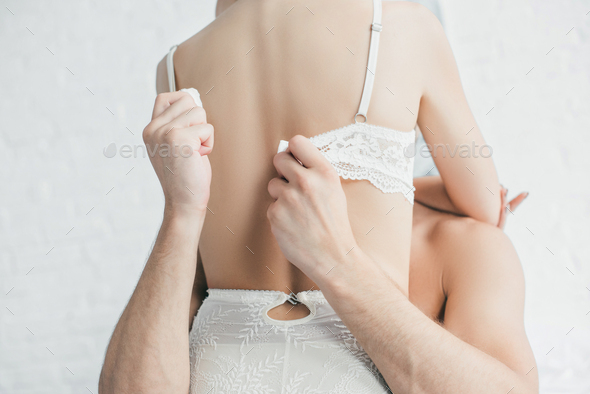 Cropped View Of Man Taking Off Bra From Sexy Woman While Lying In