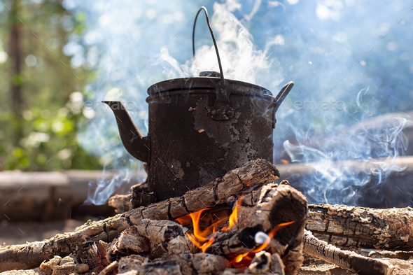 Premium Photo  Campfire camp kettle stands on fire in the stones