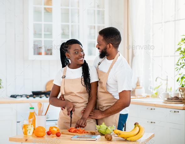 Cheerful african american girl preparing healthy salad Stock Photo by  Prostock-studio