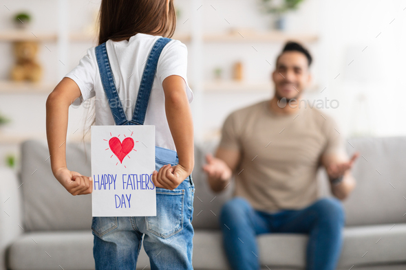 Daughter greeting excited young dad with handmade card