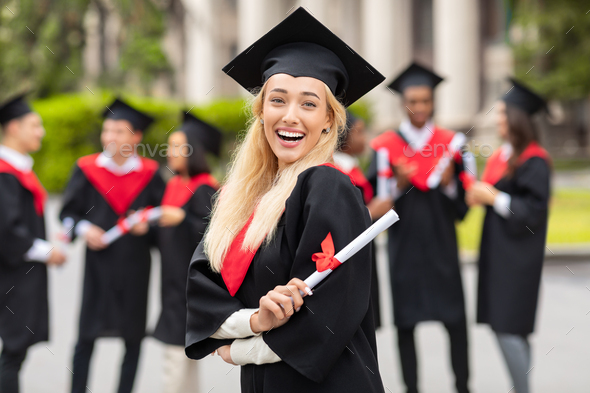Happy young woman student cheerfully posing while graduation party