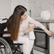 Young Handicapped Woman On Wheelchair Cleaning Stove - PhotoDune Item for Sale