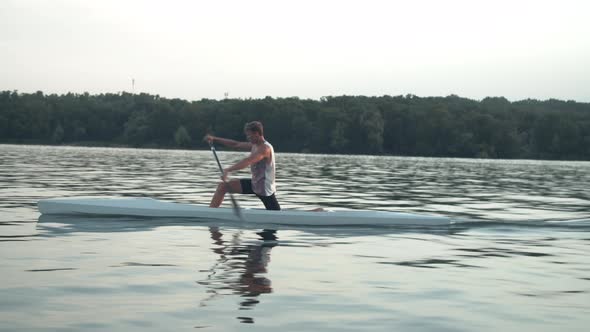 Young Man Paddling a Canoe