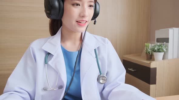 Young attractive Asian female doctor diagnosis talking and looking to camera alt