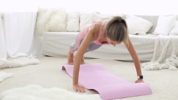 Young Sporty Woman Is Doing Fitness Push-ups Exersice on Mat in Living Room.