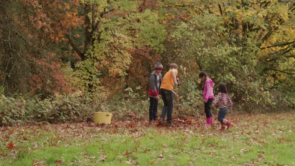 Group of kids in Fall raking leaves