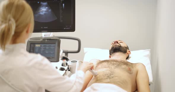 Doctor Examining Liver of Male Patient with Ultrasound Scan in Clinic