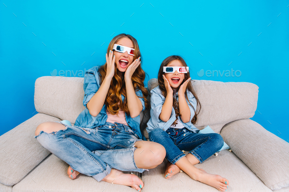 Expressing crazy happy true emotions to camera of fashionable mother and her daughter in jeans cloth