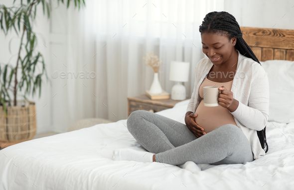 Smiling Black Expectant Mother Relaxing At Home With Cup Of Herbal Tea - Stock Photo - Images
