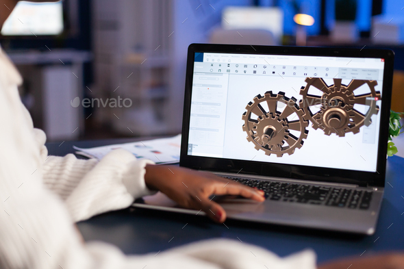 Close up of mechanical gears while engineer working with software