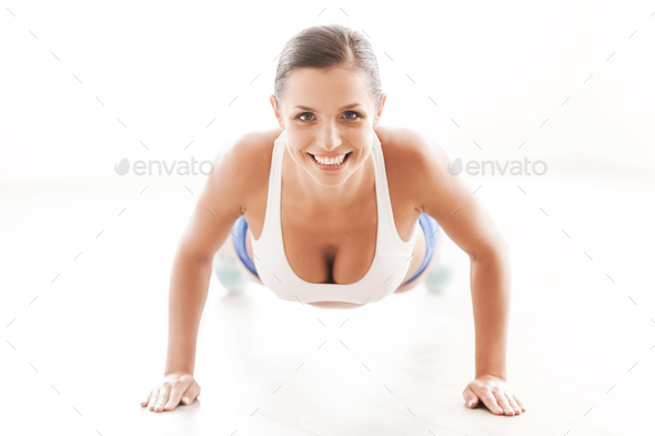 Free Photo  Frontview of young sporty girl with athletic body doing push  ups on gym floor