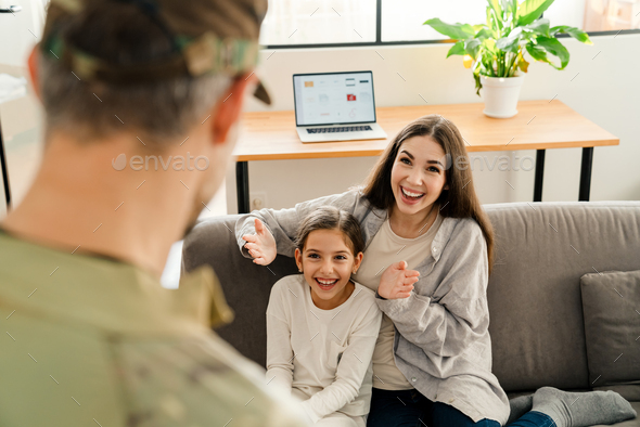 Happy kids and their mom meeting military dad