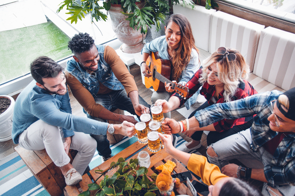 Happy multiracial friends toasting beer glasses at brewery pub Stock Photo  by engy91