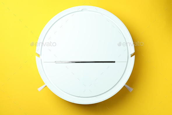 Robot vacuum cleaner on yellow background, top view