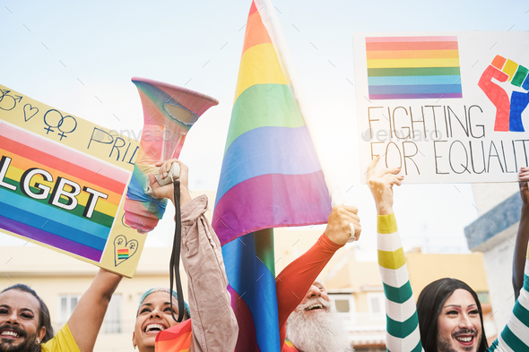 Gay people holding banners and rainbow flags at lgbt pride event outdoor