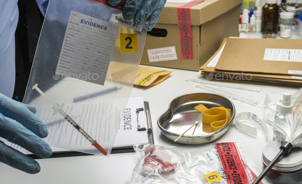 Police scientist holding evidence bag with syringe from drug overdose case, conceptual image