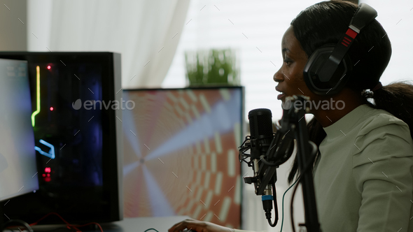 African gamer checking sound mixer sitting in gaming room